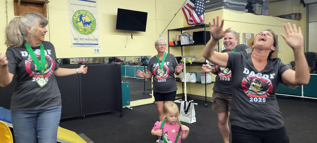 4 women and 1 toddler dancing in a dog training club
