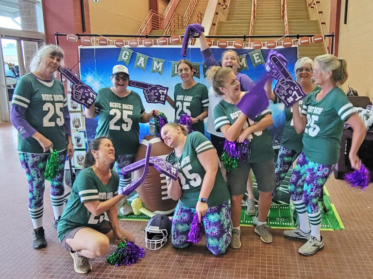 9 women in football jerseys making silly poses